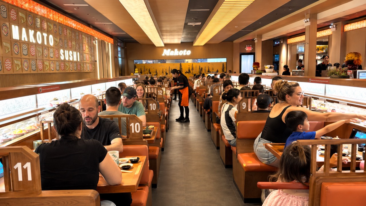 Guests dining in the booth-lined revolving sushi dining room at Makoto in Staten Island NY