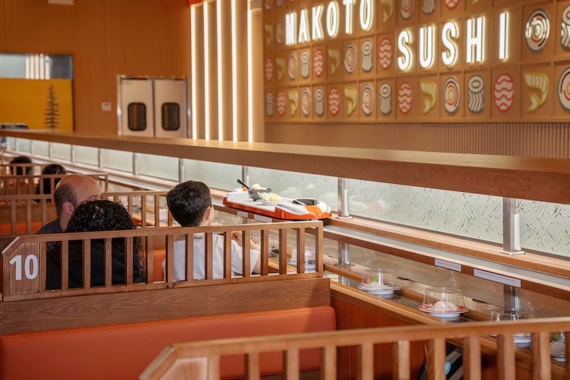 Diners at the counter beside the belt under the Makoto Sushi sign in Staten Island