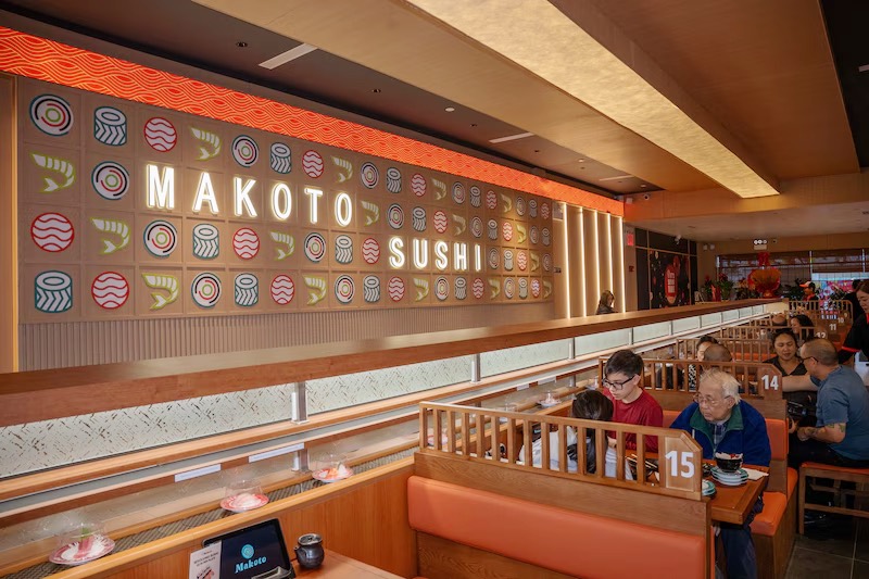 Colorful Makoto Sushi wall sign above guests dining in the Staten Island restaurant