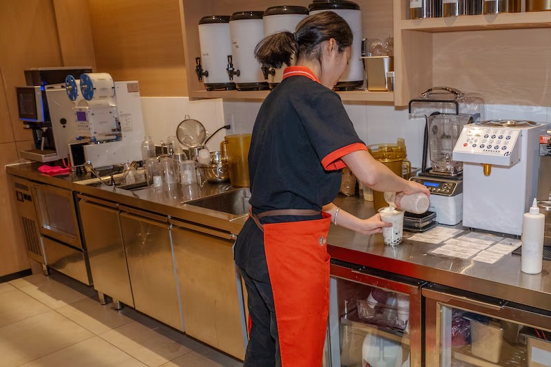 Makoto team member preparing hand-shaken bubble tea at the drink station in Staten Island