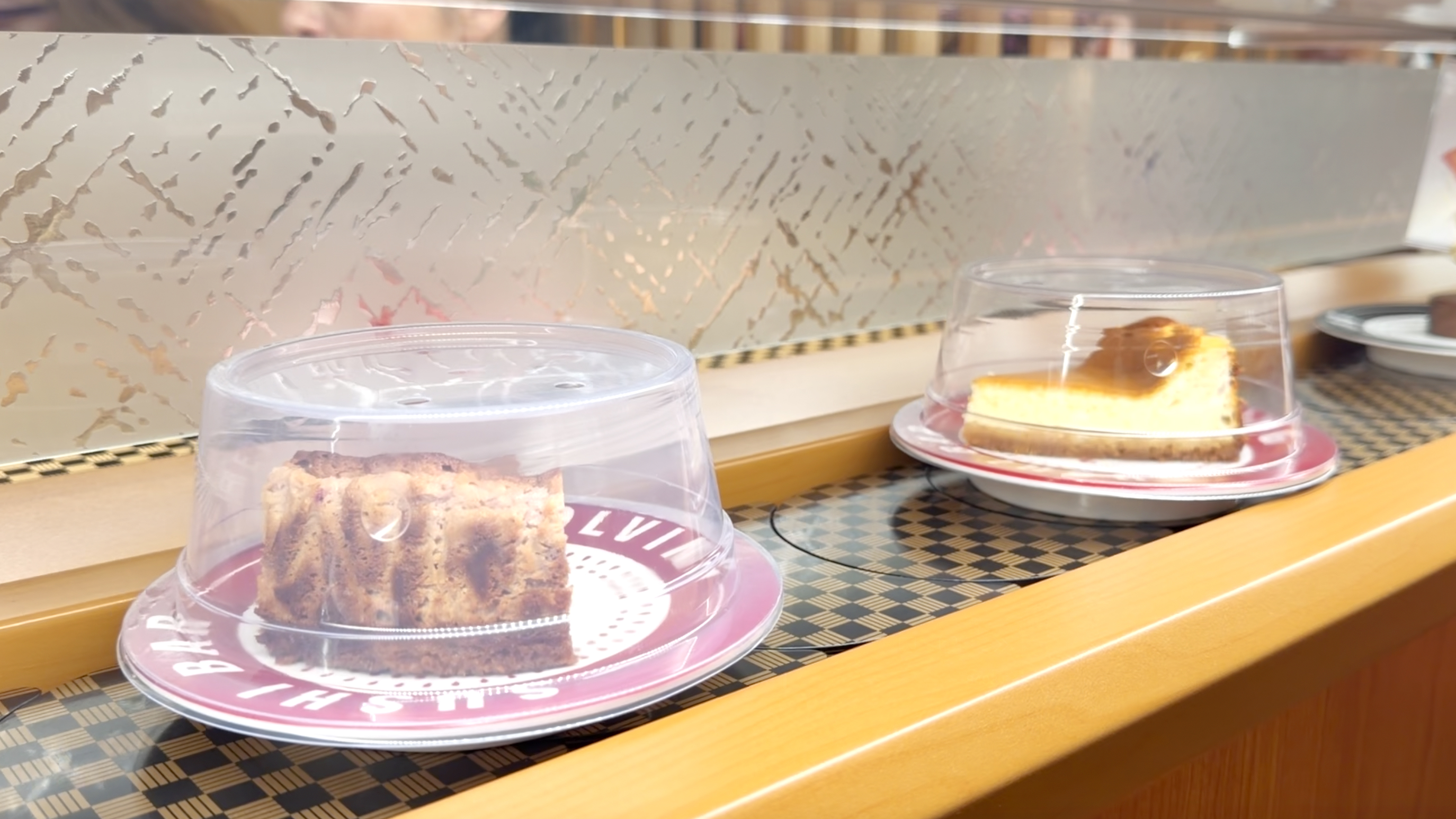 House cake square and basque cheesecake desserts rolling on the belt at Makoto Staten Island