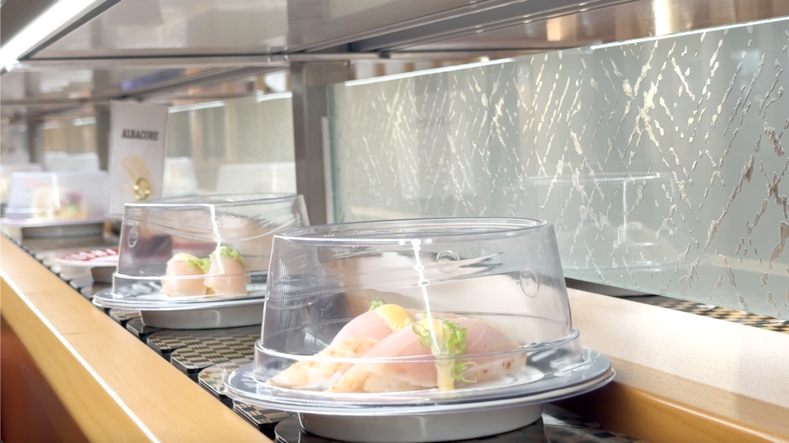 Albacore nigiri plates rolling on the conveyor belt at Makoto Staten Island