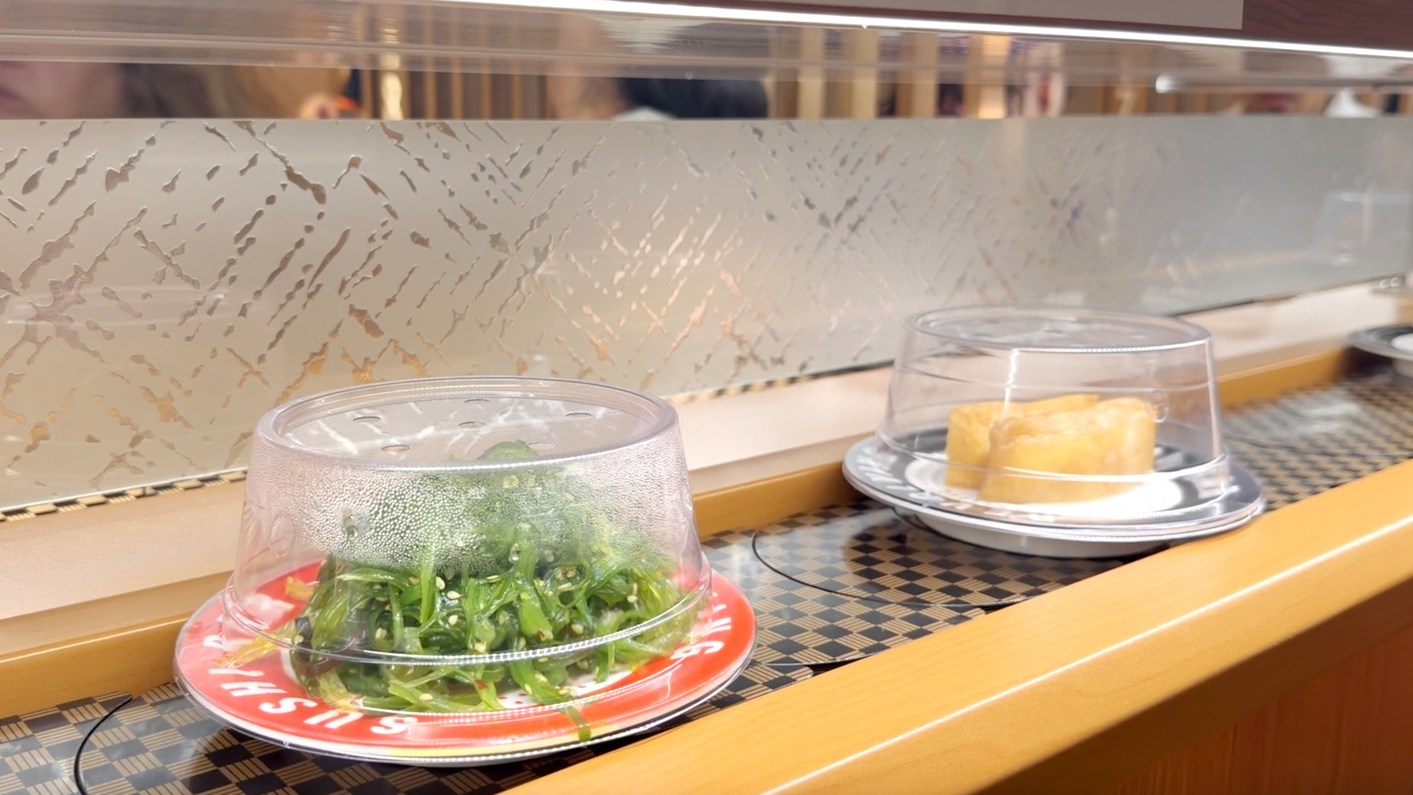 Chuka wakame seaweed salad and inari pouch plate on the belt at Makoto Staten Island