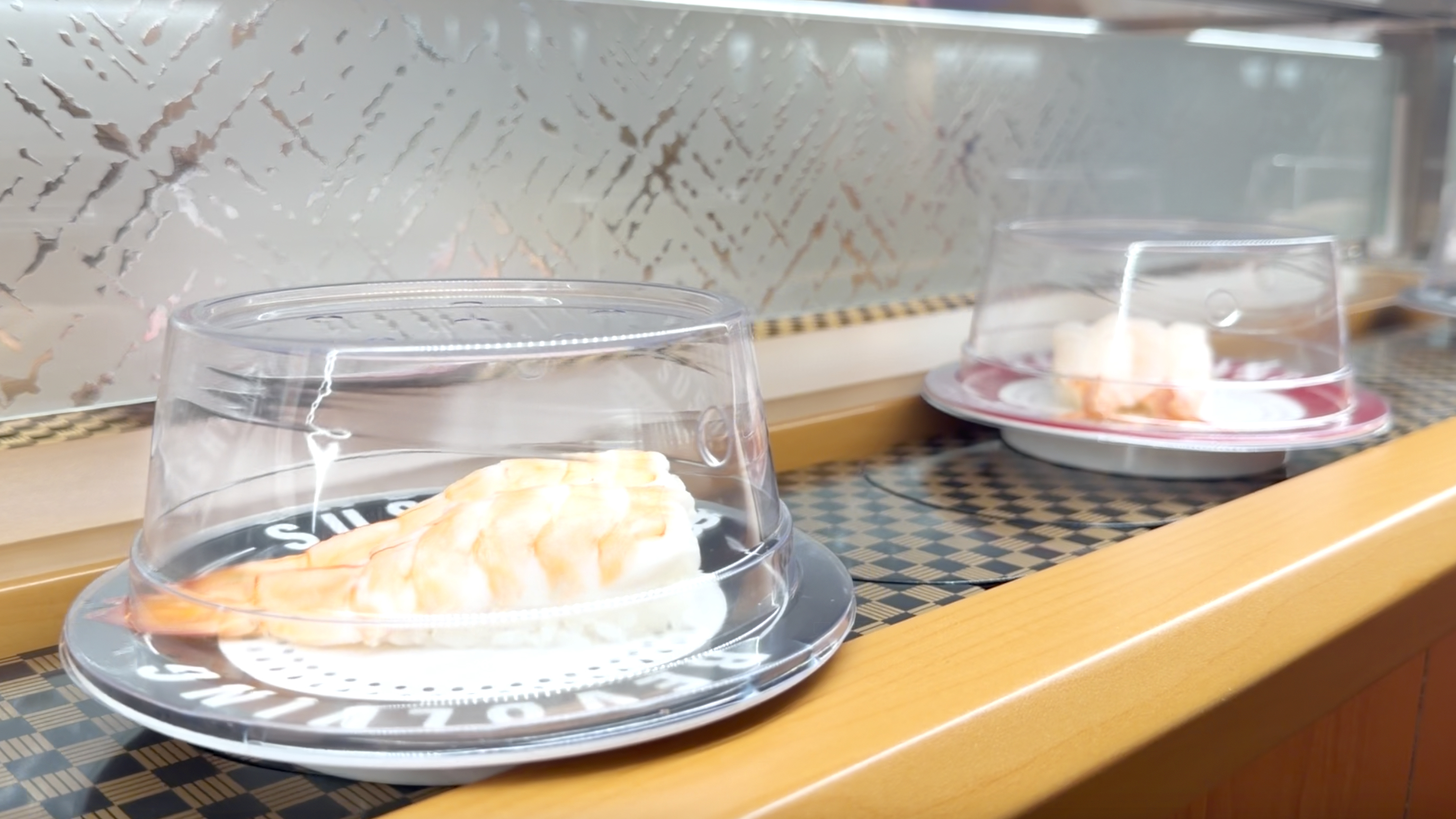 Butterflied shrimp nigiri rolling past on the belt at Makoto Staten Island